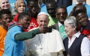 Pope Francis poses for a selfie as he greets immigrants and representatives of Caritas Internationalis during his general audience in St. Peter's Square at the Vatican Sept. 27. Caritas Internationalis was kicking off its "Share the Journey" campaign in support of immigrants. At right is Sister Norma Pimentel, executive director of Catholic Charities of the Rio Grande Valley in Texas. (CNS photo/Paul Haring) See POPE-SHARE-JOURNEY Sept. 27, 2017.