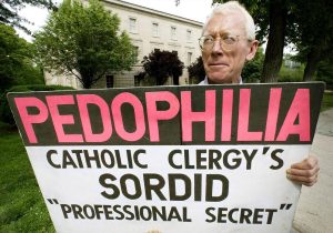 John Wojnowksi holds a placard commending the Catholic church for hiding pedophilia by priests, 14 March 2002 outside the Vatican embassy in Washington, DC where he has been protesting alone for the last four years. Wojnowksi, who declares his life was ruined after being sexually molested by a Catholic priest when he was a teenager, says he was once the subject of insults and scorn from passing motorists, but since the church's scandal began receiving extensive national media attention some three months ago, he now suffers no more insults an even gets waves and honks of affirmation from passing motorists. AFP PHOTO / Stephen JAFFE / AFP / STEPHEN JAFFE